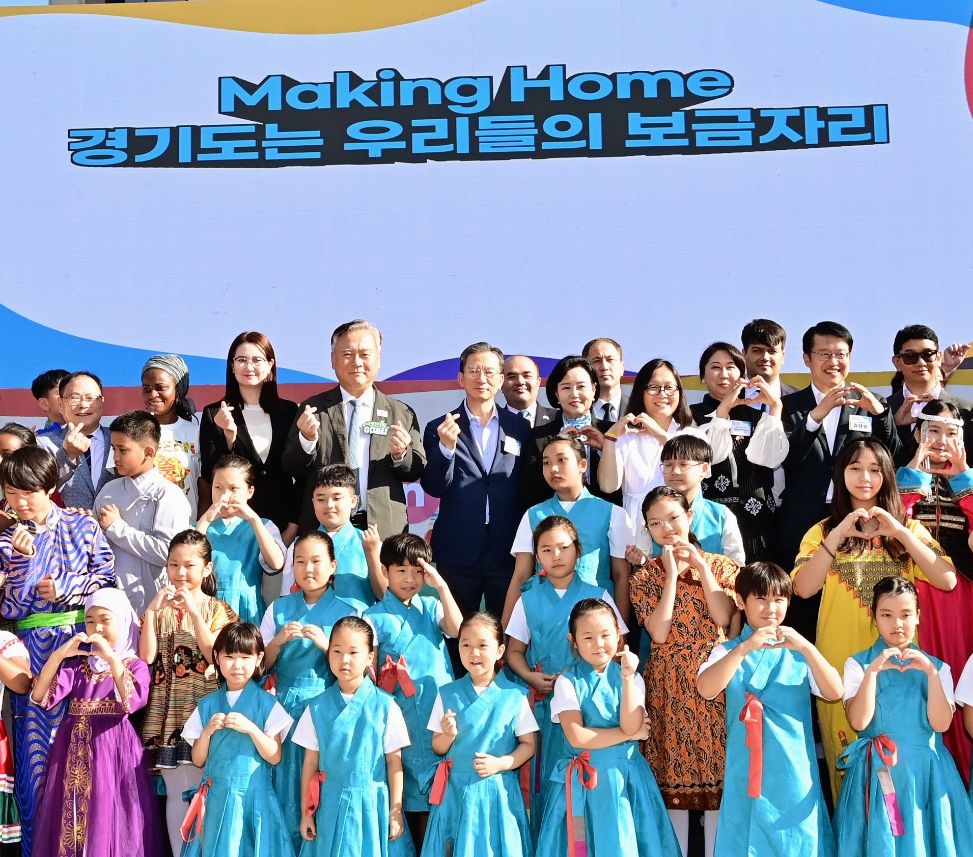 ‘2025 경기 홈 페스티벌’ 무대에서 정윤경 부의장과 내빈, 다문화가족 어린이들이 함께 손하트 퍼포먼스로 소속감과 연대를 표현하고 있다. (사진=경기도의회)