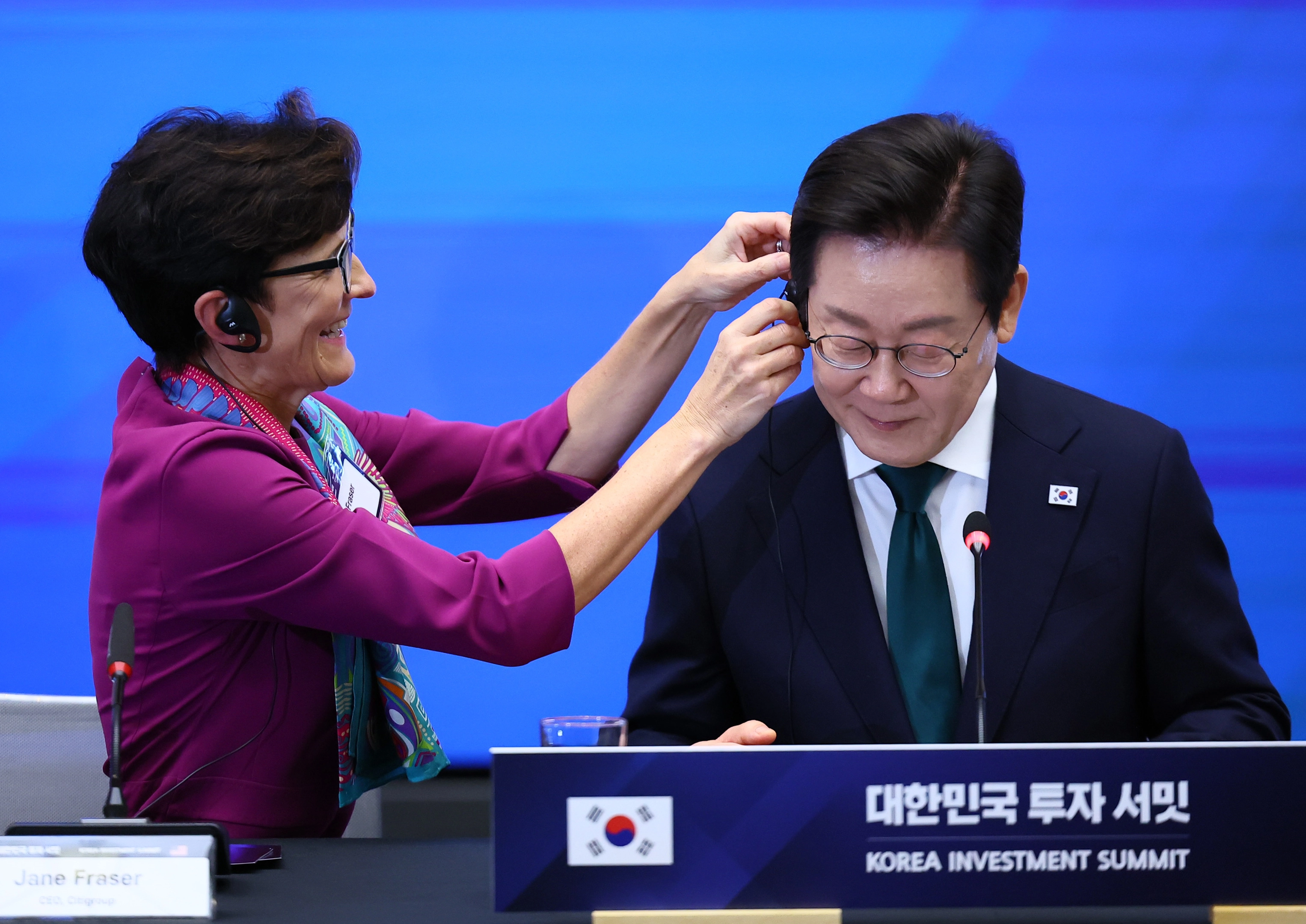 이재명 대통령, 뉴욕에서 한국경제설명회  이재명 대통령이 25일(현지시간) 미국 뉴욕 증권거래소에서 열린 한국경제설명회 투자서밋에서 제인 프레이저 씨티그룹 회장의 도움을 받아 번통역기를 착용하고 있다. 
뉴욕 연합뉴스