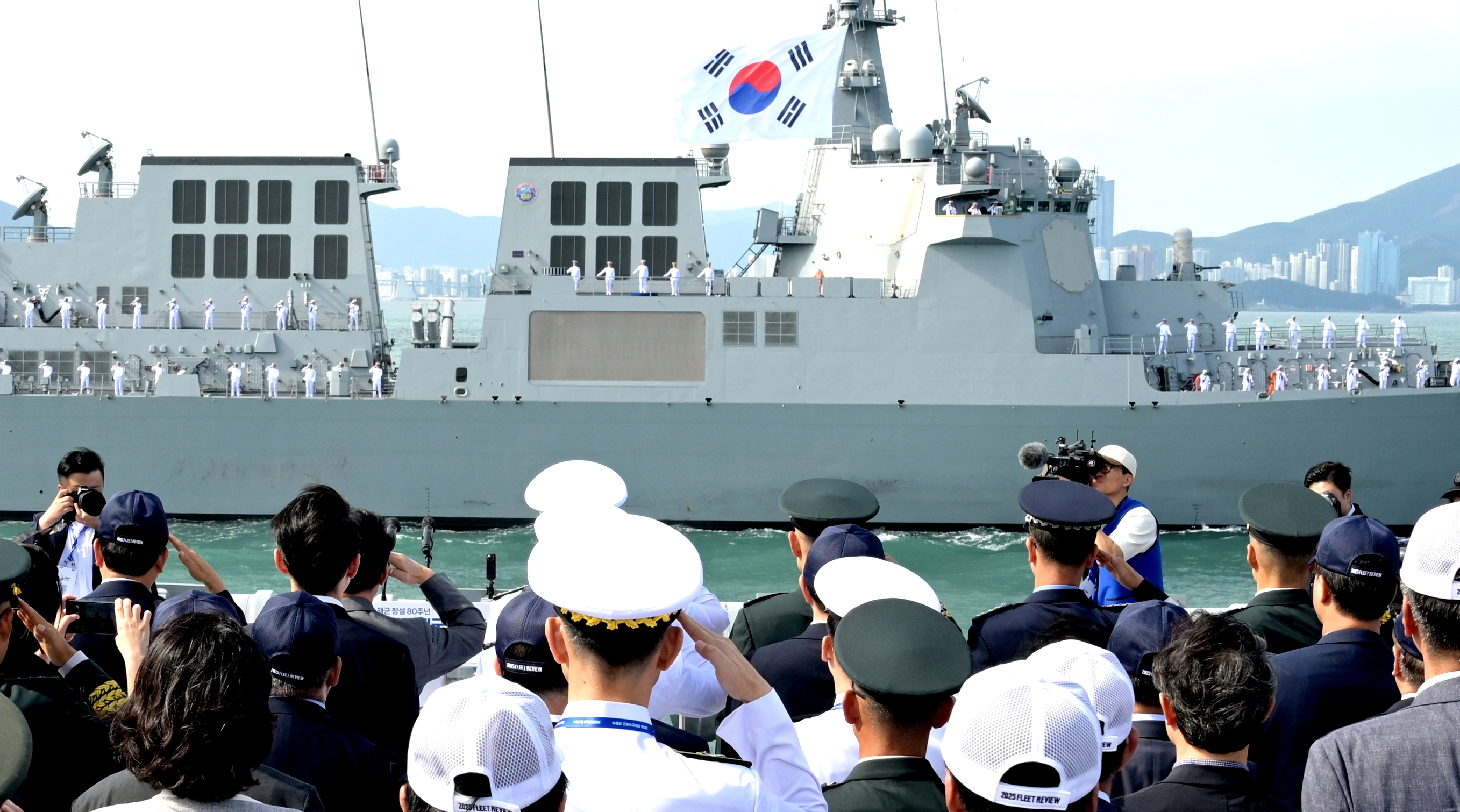 26일 부산 앞바다에서 열린 ‘2025 대한민국해군 관함식’에서 해군 장병들과 관계자들이 경례하고 있다. 2025.9.26 해군 제공