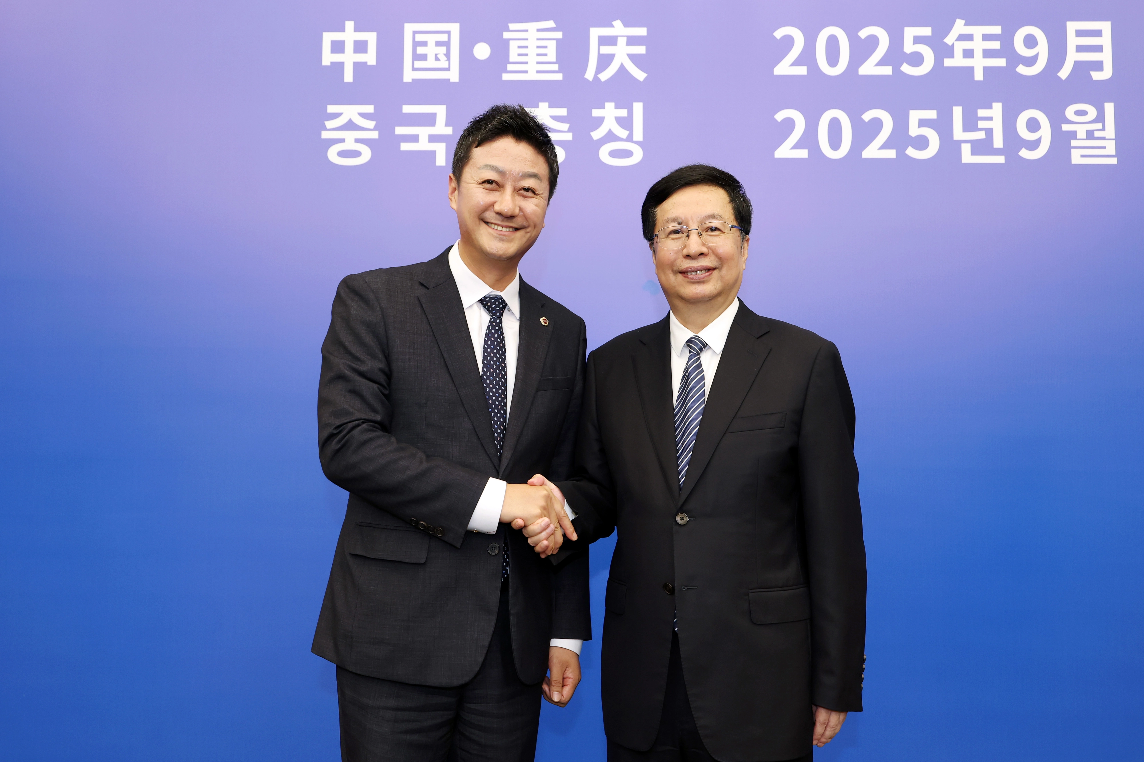 김진경 의장이 23일 후헝화(胡恒華) 충칭시장과 회담을 마치고 손을 맞잡고 기념촬영을 하고 있다. (사진=경기도의회)