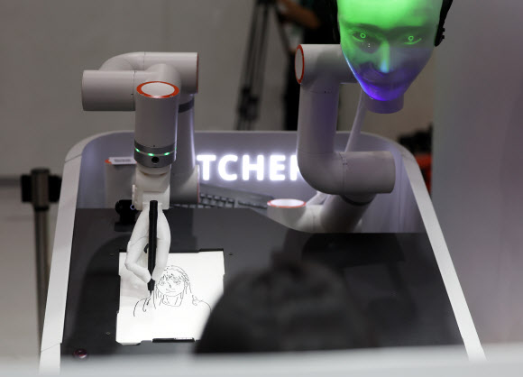 30일 서울 강남구 코엑스에서 열린 ‘스마트 라이프 위크 2025’에서 AI 로봇이 관람객의 얼굴을 그리고 있다. 2025.9.30. 연합뉴스