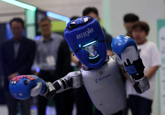 30일 강남구 코엑스에서 열린 ‘스마트라이프위크 2025’에서 관람객들이 격투하는 로봇을 구경하고 있다. 2025.9.30. 연합뉴스
