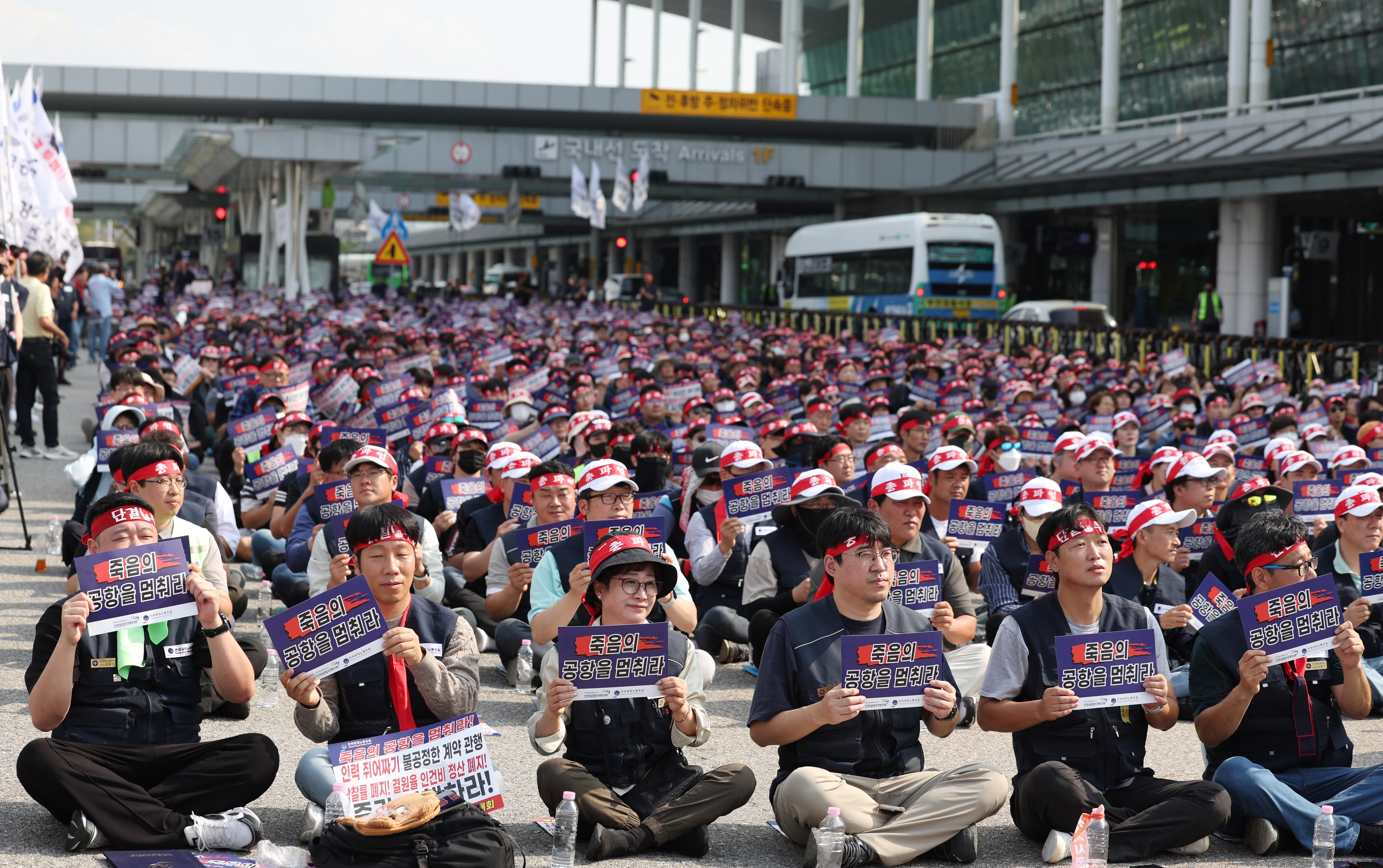 전국공항노동자연대 관계자들이 1일 서울 김포공항 국내선 3번출구에서 열린 ‘10.1 전국공항노동자 총파업대회’에서 손팻말을 흔들고 있다. 뉴시스