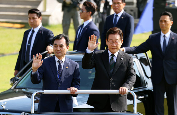 이재명 대통령이 1일 충남 계룡대 대연병장에서 열린 건군 77주년 국군의 날 기념행사에서 열병차량에 탑승해 손을 흔들고 있다. 왼쪽은 안규백 국방부 장관. 2025.10.1  연합뉴스