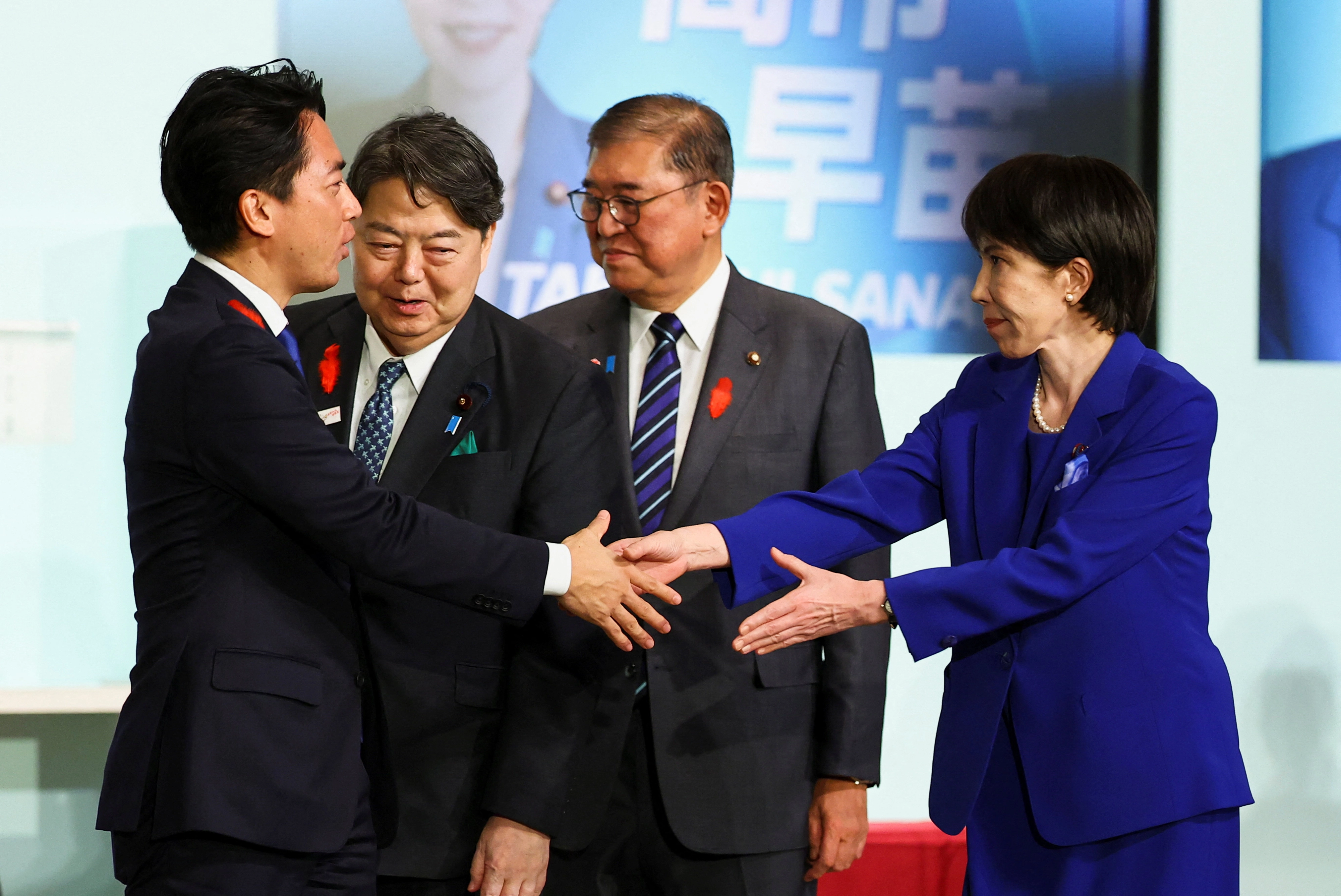 다카이치 사나에 (오른쪽) 신임 자민당 총재가 결선 투표를 벌인 고이즈미 신지로 농림수산상과 악수를 나누고 있다. 로이터 연합뉴스.