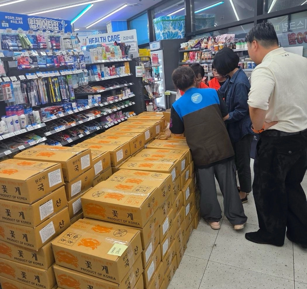 GS25 매장 안에서 고객들이 생물 꽃게를 살펴보는 모습.
GS리테일 제공