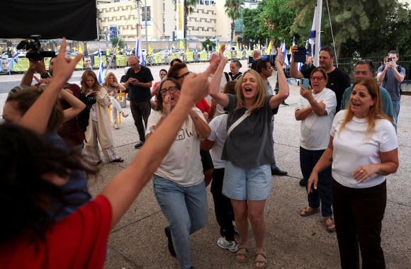 도널드 트럼프 미국 대통령이 이스라엘과 하마스가 2025년 10월 9일 이스라엘 텔아비브의 ‘호스티지 광장’에서 가자지구 휴전의 1단계에 합의했다고 발표한 후 사람들이 축하하고 있습니다. 로이터=연합뉴스 .2025-10-09