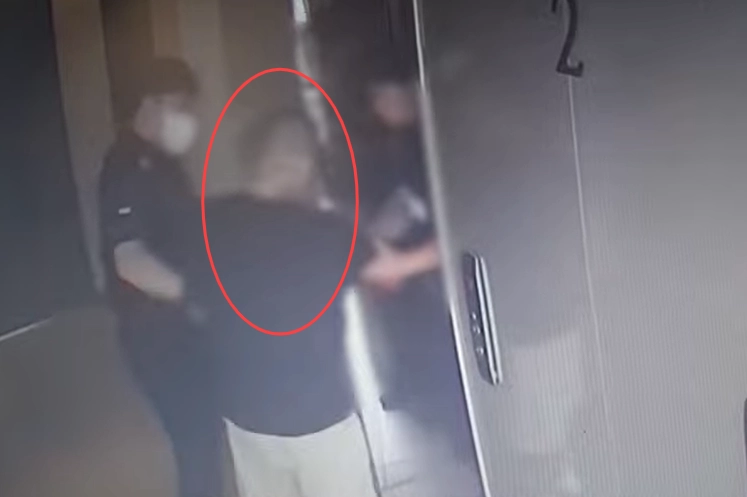 경찰에 “가족과 일이 생길 것 같다”고 신고한 뒤 연락이 끊긴 한 남성(빨간색 원)이 경찰의 부축을 받으며 호텔 엘리베이터를 타고 있다. 경찰청 유튜브 캡처