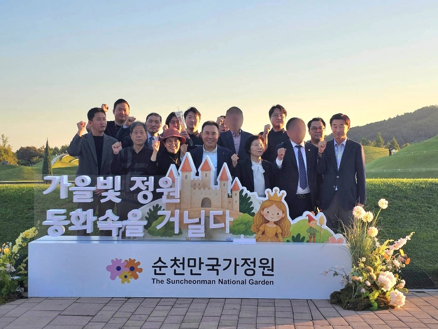 윤홍근 BBQ그룹 회장 등 회사 관계자들이 순천만국가정원에서 기념사진을 찍고 있다.