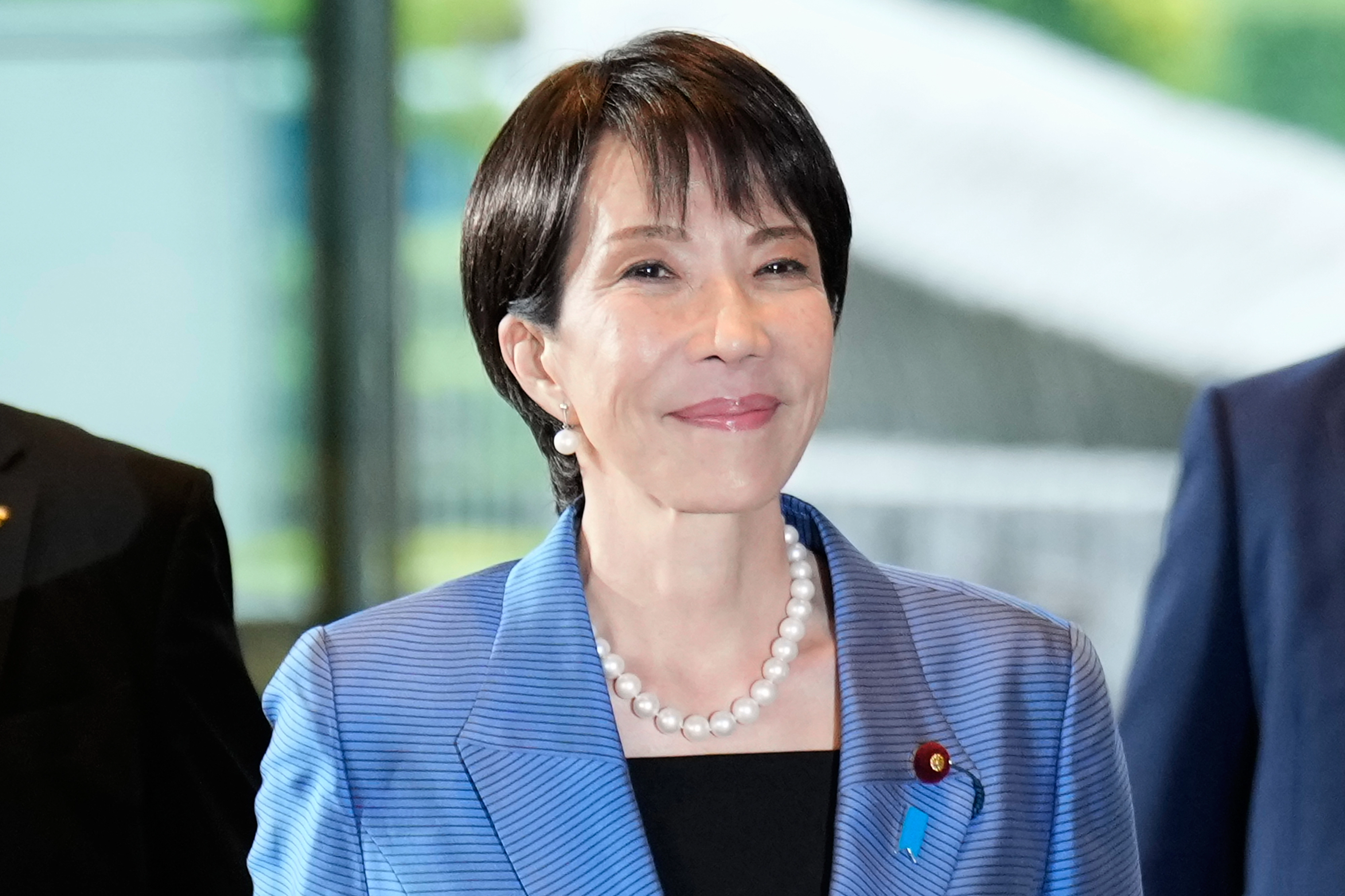 다카이치 사나에 일본 총리가 공식 취임한 21일 총리 관저로 출근하고 있는 모습. 다카이치 총리는 이날 파란 정장 재킷에 진주 목걸이를 착용했다. AP 연합뉴스