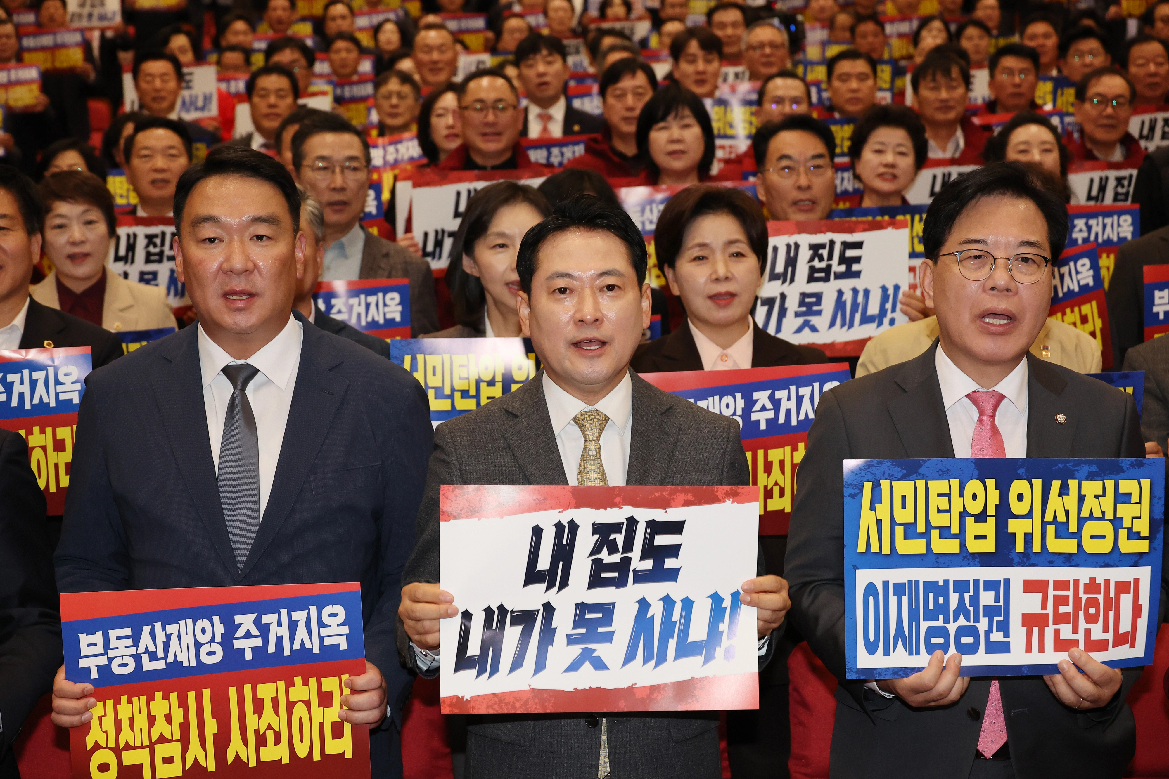 장동혁 국민의힘 대표가 27일 국회 의원회관에서 열린 전국 광역의원 및 강원도 기초의원 연수에서 손팻말을 들고 구호를 외치는 모습. 왼쪽부터 국민의힘 정희용 사무총장, 장 대표, 송언석 원내대표.
연합뉴스