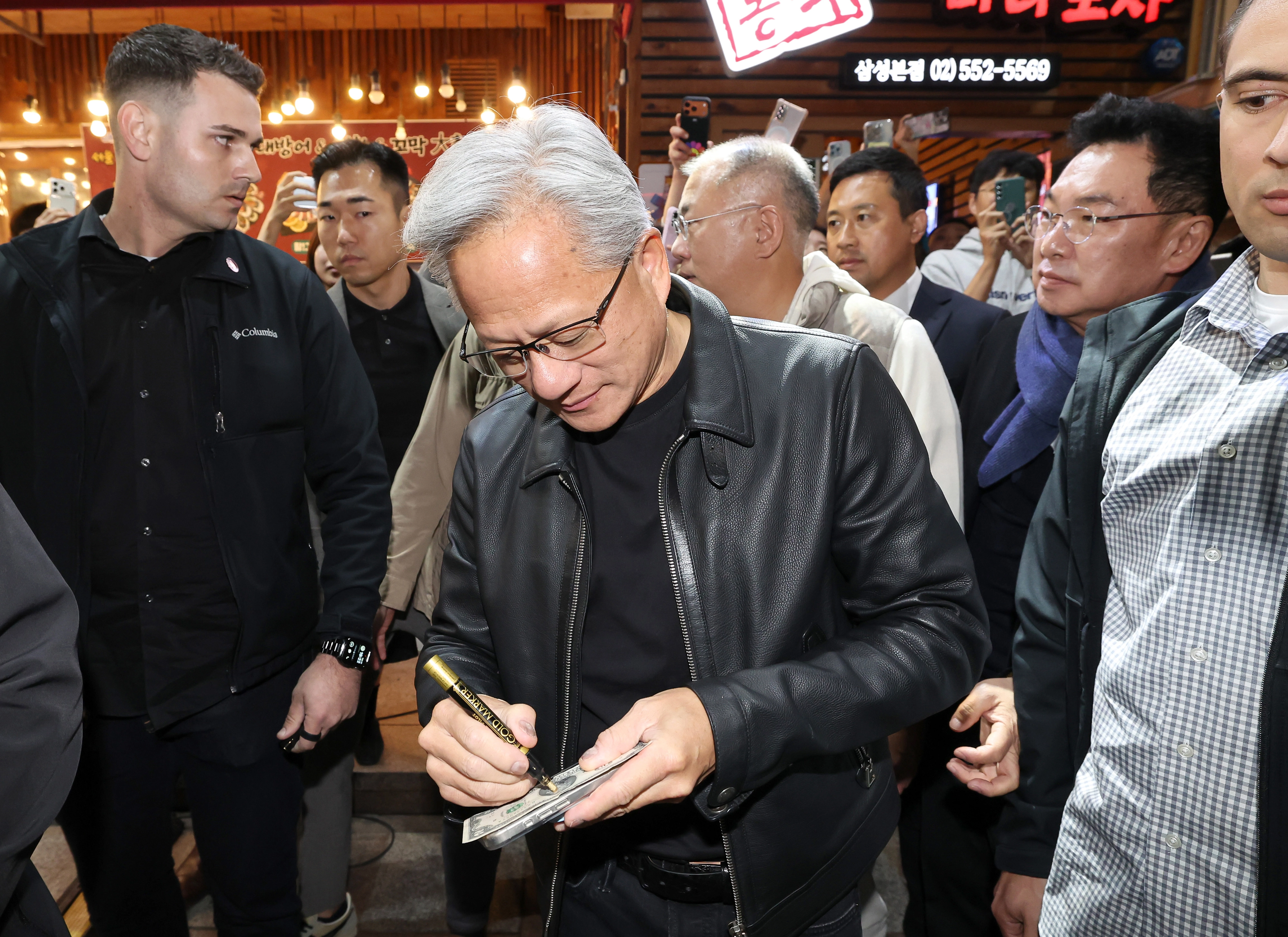 사인해주는 젠슨 황  젠슨 황 엔비디아 최고경영자가 30일 서울 삼성동 한 치킨집에서 진행된 이재용 삼성전자 회장, 정의선 현대차그룹 회장과 치맥 회동 중 시민에게 사인을 해주고 있다 . 2025.10.30 공동취재