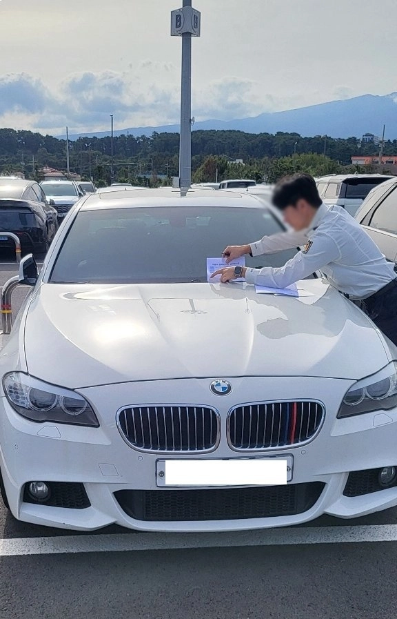 BMW차량 번호판 떼고 영치증을 붙이는 모습. 제주도 제공
