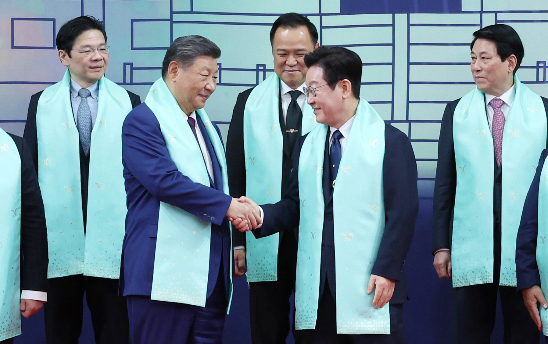 이재명 대통령, APEC 정상들과  이재명 대통령이 1일 경주화백컨벤션센터(HICO)에서 2025 아시아태평양경제협력체(APEC) 참석 정상들과 기념촬영 후 시진핑 중국 국가주석과 인사하고 있다.    뒤는 왼쪽부터 로런스 웡 싱가포르 총리, 아누틴 찬위라꾼 태국 총리, 팜 민 찐 베트남 총리. 2025.11.1 연합뉴스