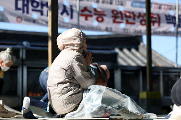 2026학년도 대학수학능력시험(수능)을 열흘 앞둔 3일 경북 경산시 팔공산 갓바위에서 한 불자가 두꺼운 옷과 방한용품을 갖추고 기도하고 있다. 2025.11.3  연합뉴스