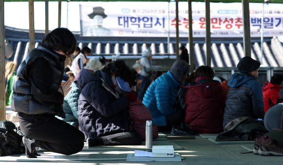 2026학년도 대학수학능력시험(수능)을 열흘 앞둔 3일 경북 경산시 팔공산 갓바위에서 불자들이 두꺼운 옷 등 방한용품을 착용하고 기도하고 있다. 2025.11.3  연합뉴스