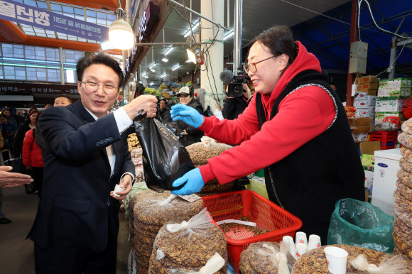 김민석 국무총리가 3일 서울 동대문구 경동시장에서 농축산물 물가 상황을 점검하던 중 번데기를 구입하고 있다. 2025.11.3. 연합뉴스