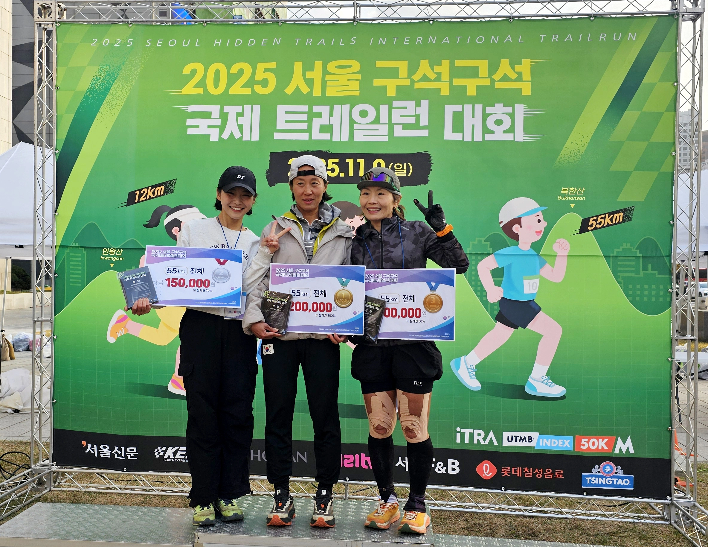 ‘2025 서울 구석구석 국제 트레일런 대회’ 55㎞ 여자 부문에서 입상한 선수들이 상패를 들고 기념 촬영을 하고 있다.  가운데가  8시간 45분의 기록으로 우승을 차지한  황지호씨.