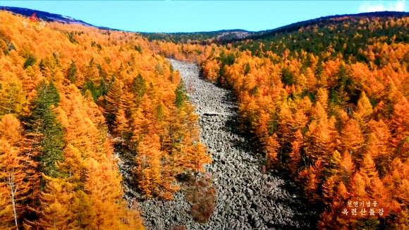 북한 조선중앙TV가 12일 방영한 함경남도 부전군 옥련산돌강의 가을 풍경. 천연기념물인 옥련산돌강은 산봉우리 암괴들이 강골짜기를 따라 이동해 깔린 것으로 너비 약 120m, 길이 약 700m에 달하며 돌밭 밑으로 물소리만 들리고 물은 보이지 않는 것으로 알려져 있다. 2025.11.12  조선중앙TV 화면