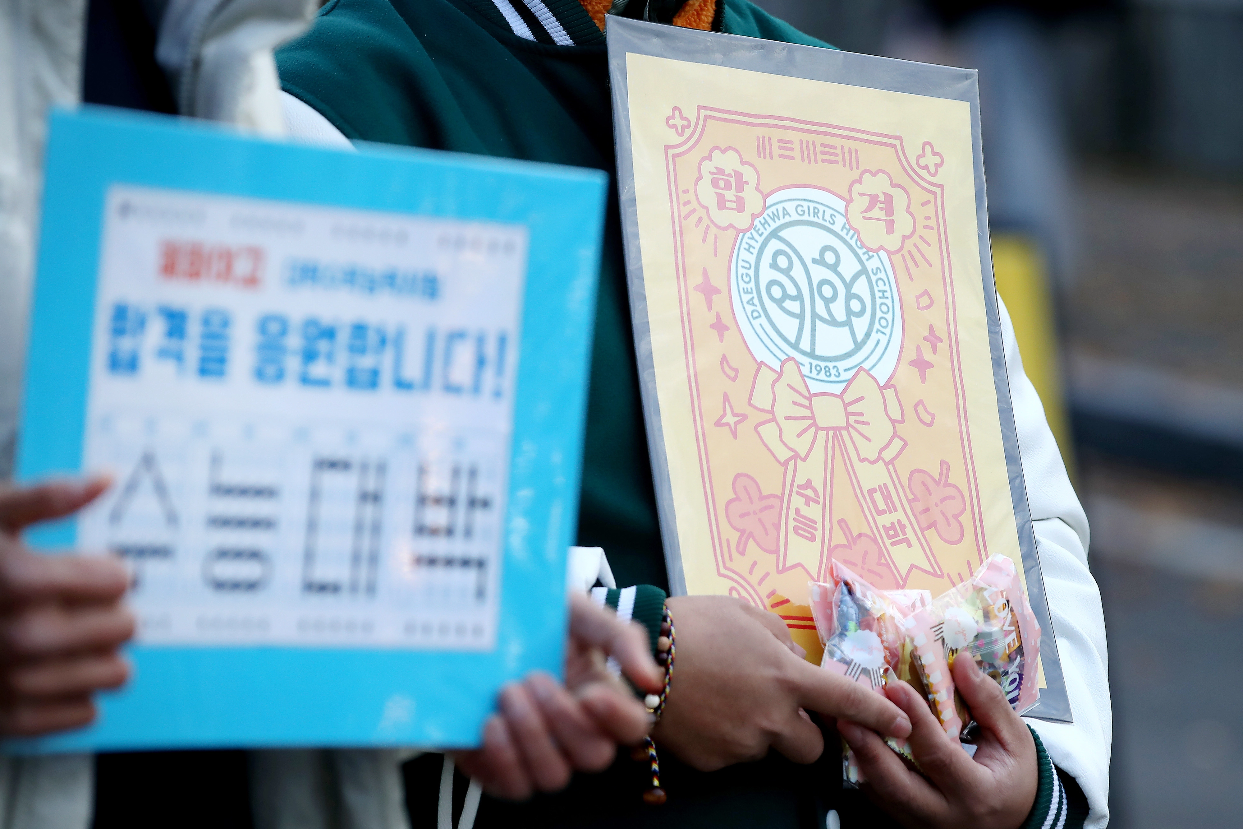 수능대박!  2026학년도 대학수학능력시험일인 13일 오전 대구 수성구 정화여고에 마련된 시험장 앞에서 출신학교 교사들이 간식과 부적을 준비해 수험생을 응원하고 있다. 2025.11.13. 뉴스1