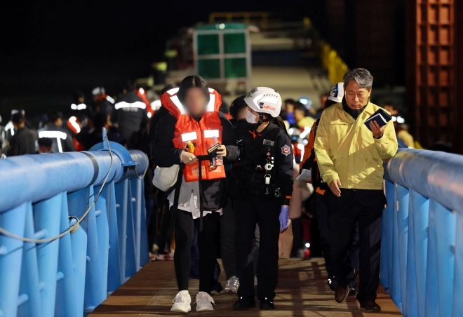 19일 오후 전남 목포시 목포해양경찰서 전용 부두로 여객선 퀸제누비아2호 탑승객들이 구조돼 이동하고 있다.<br>267명이 탑승한 퀸제누비아2호는 이날 오후 8시 17분쯤 전남 신안군 장산도 남방 족도에 좌초됐다. 2025.11.19. 연합뉴스