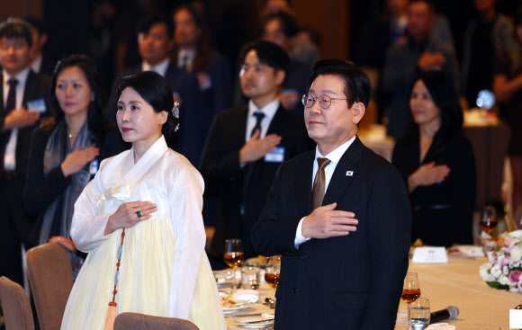 이집트를 공식 방문 중인 이재명 대통령과 김혜경 여사가 20일(현지시간) 카이로의 한 호텔에서 열린 동포·지상사 간담회에서 국기에 경례하고 있다. 2025.11.21 연합뉴스