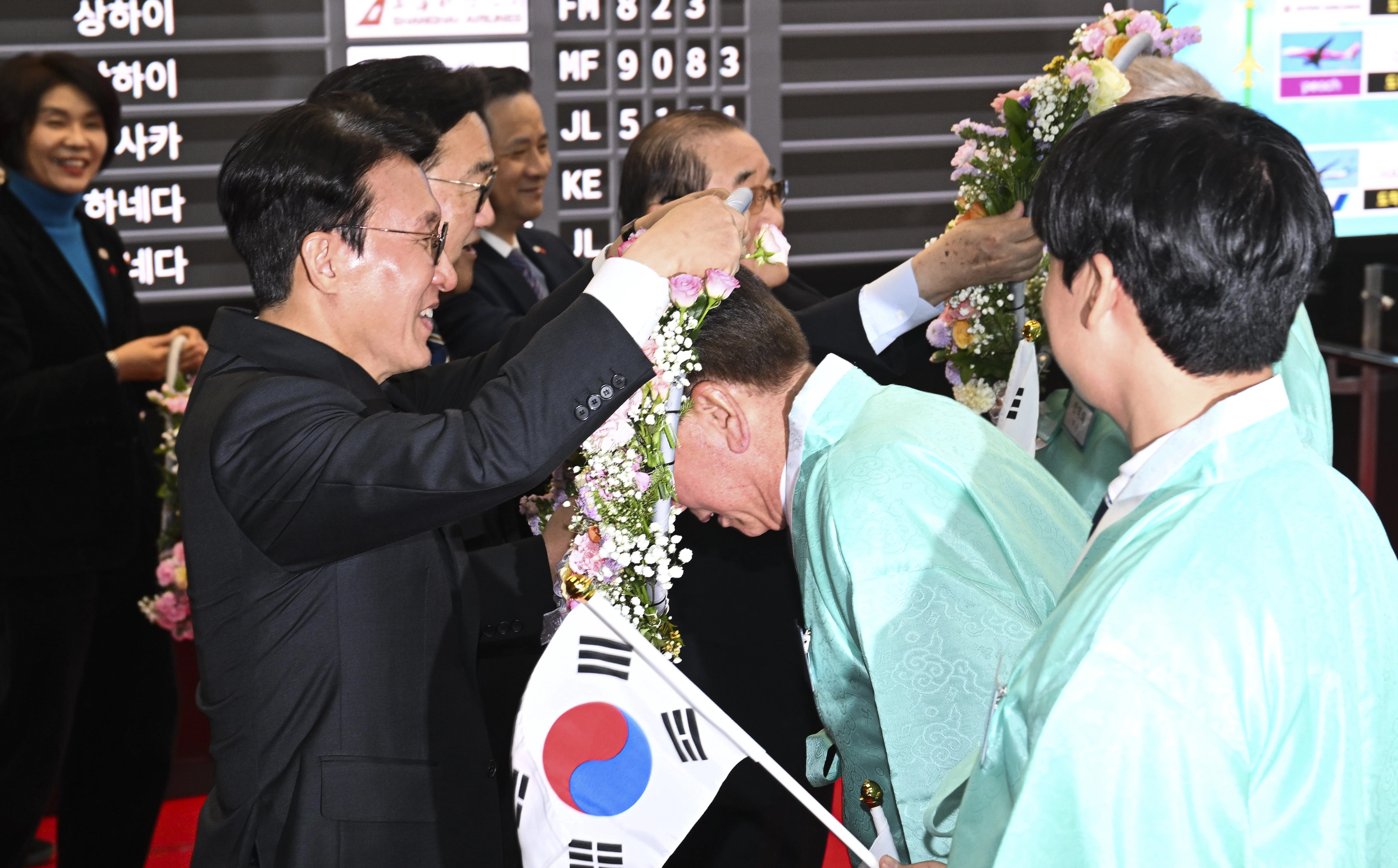 김민석 국무총리와 우원식 국회의장이  23일 서울 강서구 김포국제공항 국제선 입국장에서 열린 ‘대한민국임시정부 요인 환국 재현’ 행사에서 임시정부 요인 후손들에게 꽃 목걸이를 걸고 있다. 2025.11.23 이지훈 기자