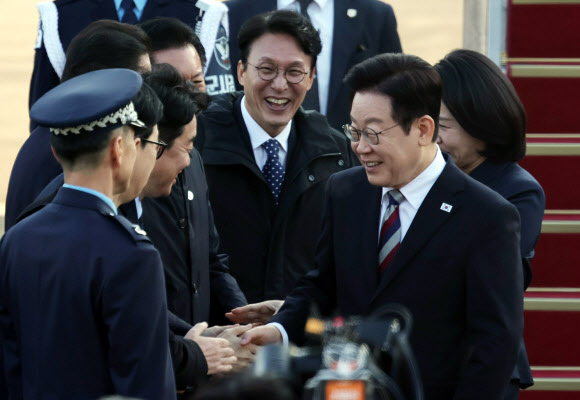 아프리카·중동 4개국 순방을 마치고 귀국한 이재명 대통령이 26일 성남 서울공항에서 환영나온 김민석 국무총리, 강훈식 대통령비서실장 등과 인사하고 있다. 2025.11.26 연합뉴스