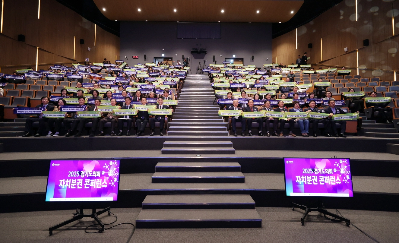 ‘2025 경기도의회 자치분권 콘퍼런스’에 참석한 참가자들이 자치분권 실현을 염원하는 문구가 적힌 손피켓을 들고 기념촬영을 하고 있다.(사진=경기도의회)