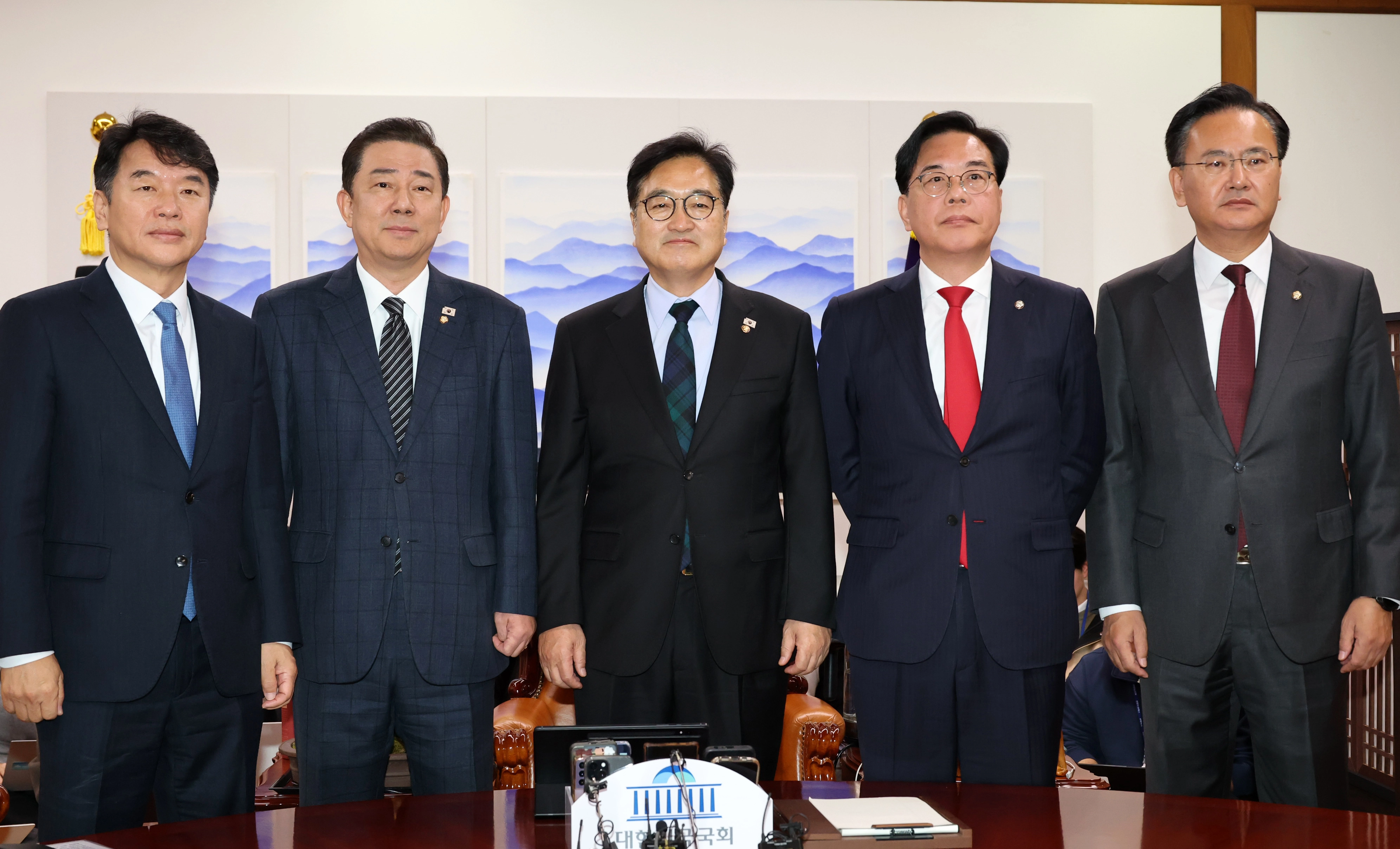 더불어민주당 김병기 원내대표와 국민의힘 송언석 원내대표가 27일 서울 여의도 국회에서 우원식 국회의장 주재로 열린 여야 교섭단체 원내대표 회동에서 만나 기념 촬영하고 있다. 왼쪽부터 더불어민주당 문진석 원내운영수석부대표·김병기 원내대표, 우원식 의장, 국민의힘 송언석 원내대표·유상범 원내운영수석부대표. 2025.11.27 공동취재