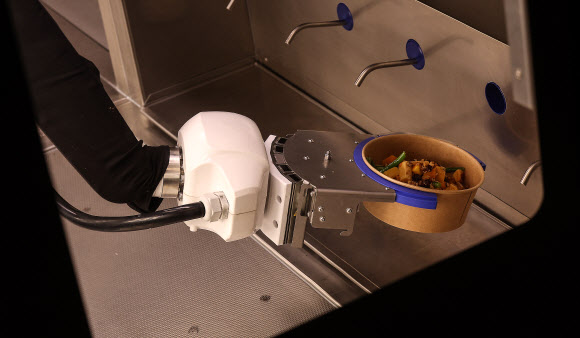 28일 대구 남구 주한미군 제19 지원사령부 캠프 워커에 설치된 자동화 식당인 ‘마켓 19’에서 로봇이 급식을 조리하고 있다. 해당 식당은 미 육군 최초의 자동화 식당으로 이달부터 6개월간 시범 운영한다. 2025.11.28 연합뉴스