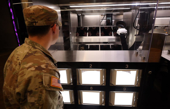 28일 대구 남구 주한미군 제19 지원사령부 캠프 워커에 설치된 자동화 식당인 ‘마켓 19’에서 한 미군이 로봇이 조리하는 급식을 기다리고 있다. 해당 식당은 미 육군 최초의 자동화 식당으로 이달부터 6개월간 시범 운영한다. 2025.11.28 연합뉴스