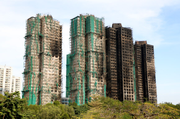 28일(현지시간) 홍콩 북부 타이포의 고층 아파트 단지 웡 푹 코트에서 난 불이 완전히 꺼지고 그을음이 남은 모습. 타다 만 안전그물과 대나무 비계가 건물에 붙어있다. 2025.11.28. 연합뉴스