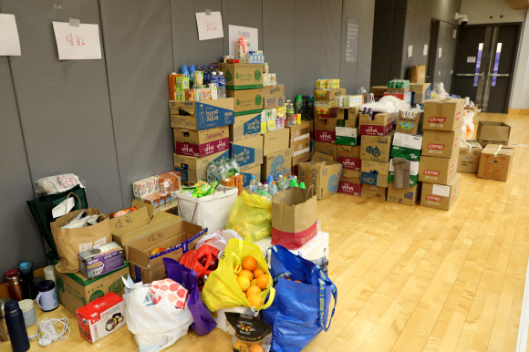 28일 오전 10시 44분(현지시간)께 임시 대피소로 쓰이는 홍콩 북부 타이포 퉁 청 시민회관 3층 강당에 화재 피해자들을 위한 음료, 과일, 핫팩, 텀블러 등 구호 물품이 상자째로 쌓여있다. 2025.11.28. 연합뉴스