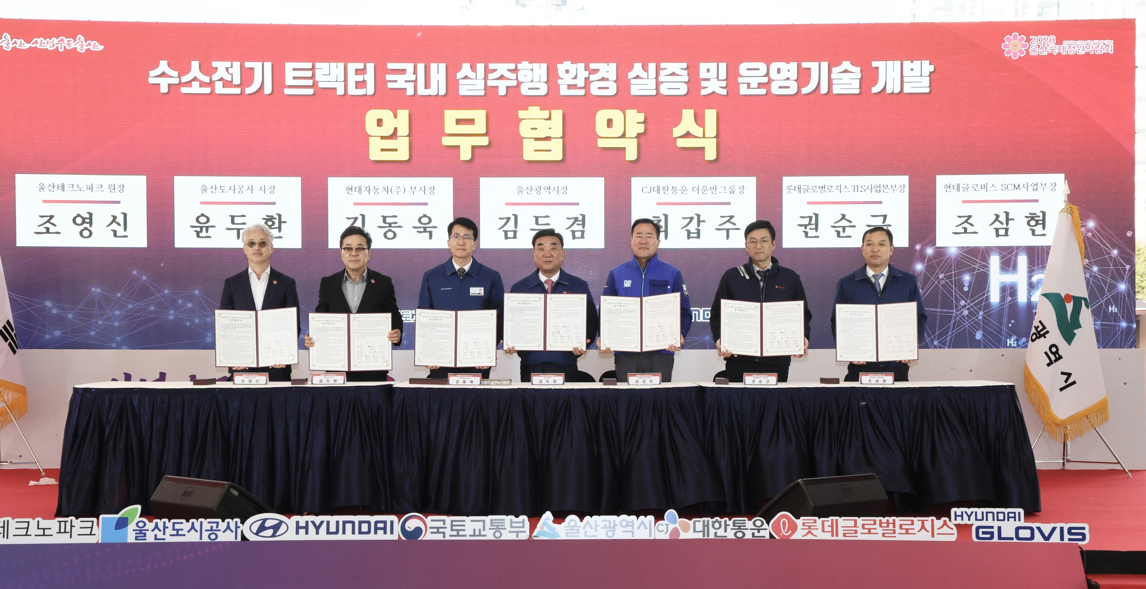2일 오후 울산 태화강 남구둔치에서 ‘수소전기 트랙터 국내 실주행 환경 실증 및 운영기술 개발 업무 협약식’이 열렸다. 사진 왼쪽부터 조영신 울산테크노파크원장, 윤두환 울산도시공사 사장, 김동욱 현대자동차 부사장, 김두겸 울산시장, 최갑주 CJ대한통운 더운반그룹장, 권순근 롯데글로벌로지스 TLS사업본부장, 조삼현 현대글로비스 SCM사업부장. 울산시 제공