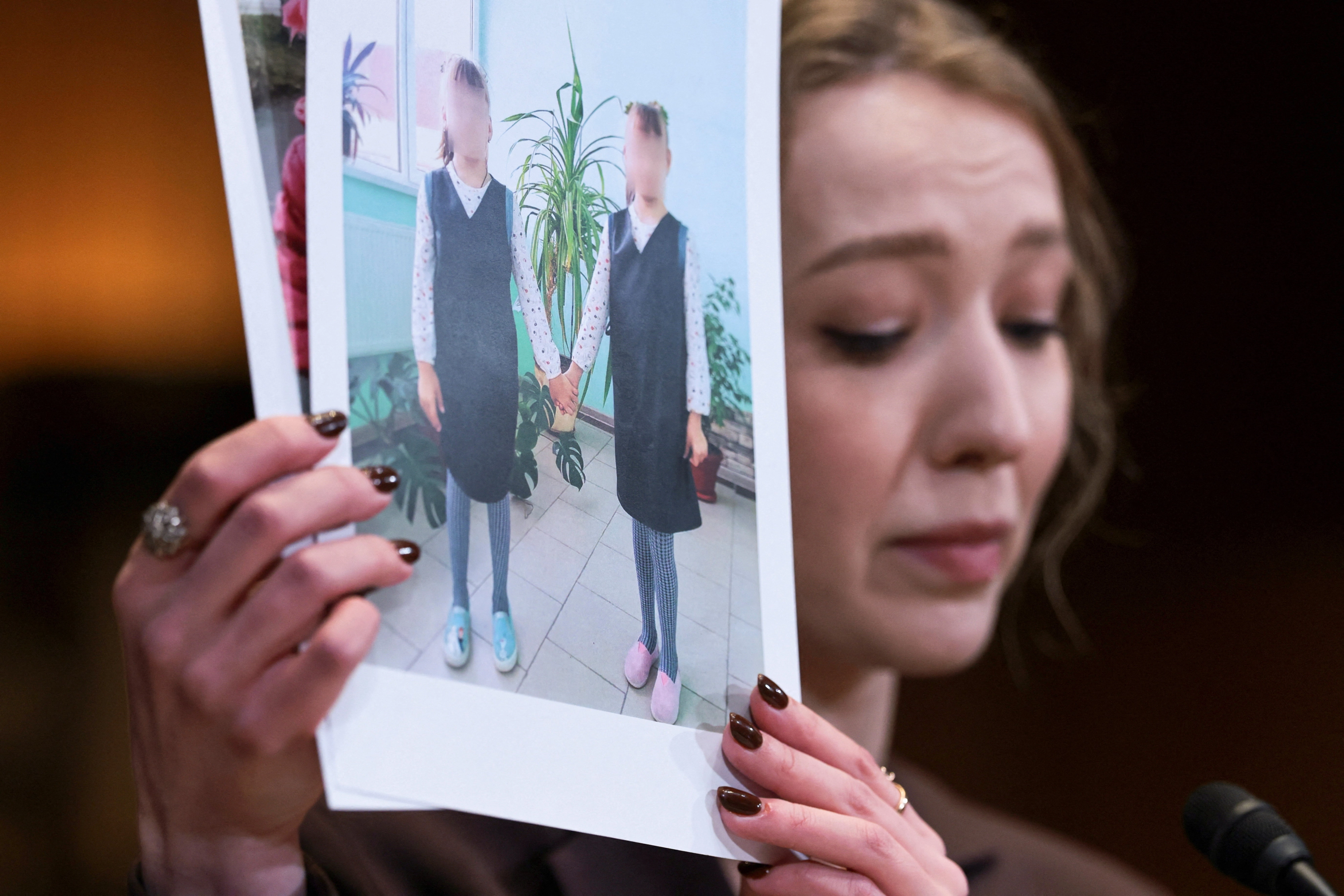 ‘우크라이나 지역인권센터’ 소속 변호사인 카테리나 라셰프스카가 3일(현지시간) 미국 워싱턴D.C. 국회의사당에서 열린 상원 청문회에 출석해, 러시아군의 우크라이나 어린이 납치 문제에 대해 증언하며 피해 우크라이나 어린이들의 사진을 들고 있다. 2025.12.3 워싱턴 로이터 연합뉴스