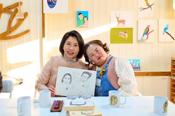 김혜경 여사가 3일 경기도 양평 ‘어메이징 아웃사이더 아트센터’에서 열린 정은혜 작가의 개인전 ‘은혜로운 명화전’을 찾아 정 작가와 함께 기념촬영을 하고 있다. 2025.12.4  대통령실 제공