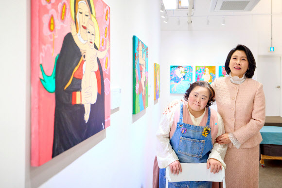 김혜경 여사가 3일 경기도 양평 ‘어메이징 아웃사이더 아트센터’에서 열린 정은혜 작가의 개인전 ‘은혜로운 명화전’을 찾아 정 작가와 작품을 함께 둘러보고 있다. 2025.12.4  대통령실 제공