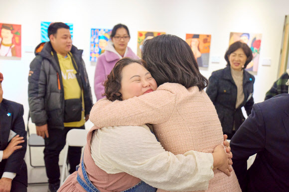 김혜경 여사가 3일 경기도 양평 ‘어메이징 아웃사이더 아트센터’에서 열린 정은혜 작가의 개인전 ‘은혜로운 명화전’을 찾아 정 작가와 포옹하며 인사하고 있다. 2025.12.4  대통령실 제공