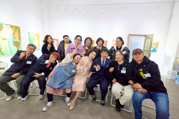 김혜경 여사가 3일 경기도 양평 ‘어메이징 아웃사이더 아트센터’에서 열린 정은혜 작가의 개인전 ‘은혜로운 명화전’을 찾아 정 작가를 비롯한 관계자들과 기념촬영을 하고 있다. 2025.12.4  대통령실 제공