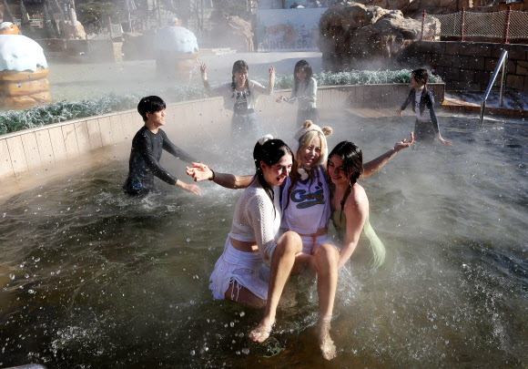 한파가 이어지고 있는 4일 경기도 용인시 캐리비안베이에서 모델들이 카피바라 테마로 꾸며진 편백 나무 노천탕과 핀란드식 원통 사우나 등 ‘윈터 캐비 스파’를 즐기고 있다. 2025.12.4  연합뉴스