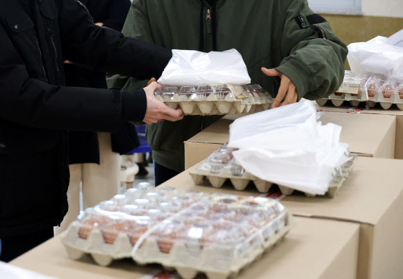학교 급식·돌봄 비정규직 노동자들이 파업에 돌입한 4일 대전의 한 고등학교에서 학생들이 대체 급식으로 제공된 달걀 꾸러미와 빵과 음료수 등이 담긴 박스를 학급으로 옮기고 있다. 2025.12.4  연합뉴스