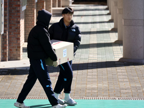 학교 급식·돌봄 비정규직 노동자들이 파업에 돌입한 4일 대전의 한 고등학교에서 학생들이 대체 급식으로 제공된 빵과 음료수 꾸러미를 학급으로 옮기고 있다. 2025.12.4  연합뉴스