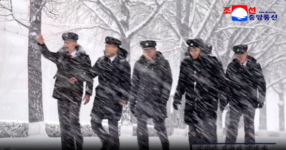 지난 4일 평양에 첫눈이 내린 가운데 학생들이 거리를 걸으며 눈을 맞고 있다. 이날 평양 지역 강설량은 평균 9cm를 기록했다고 조선중앙통신이 5일 보도했다. 2025.12.5  평양 조선중앙통신 연합뉴스