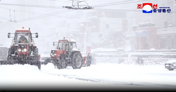 지난 4일 평양에 첫눈이 내린 가운데 제설 차량들이 시내 도로 위 눈을 치우고 있다. 이날 평양 지역 강설량은 평균 9cm를 기록했다고 조선중앙통신이 5일 보도했다. 2025.12.5  평양 조선중앙통신 연합뉴스