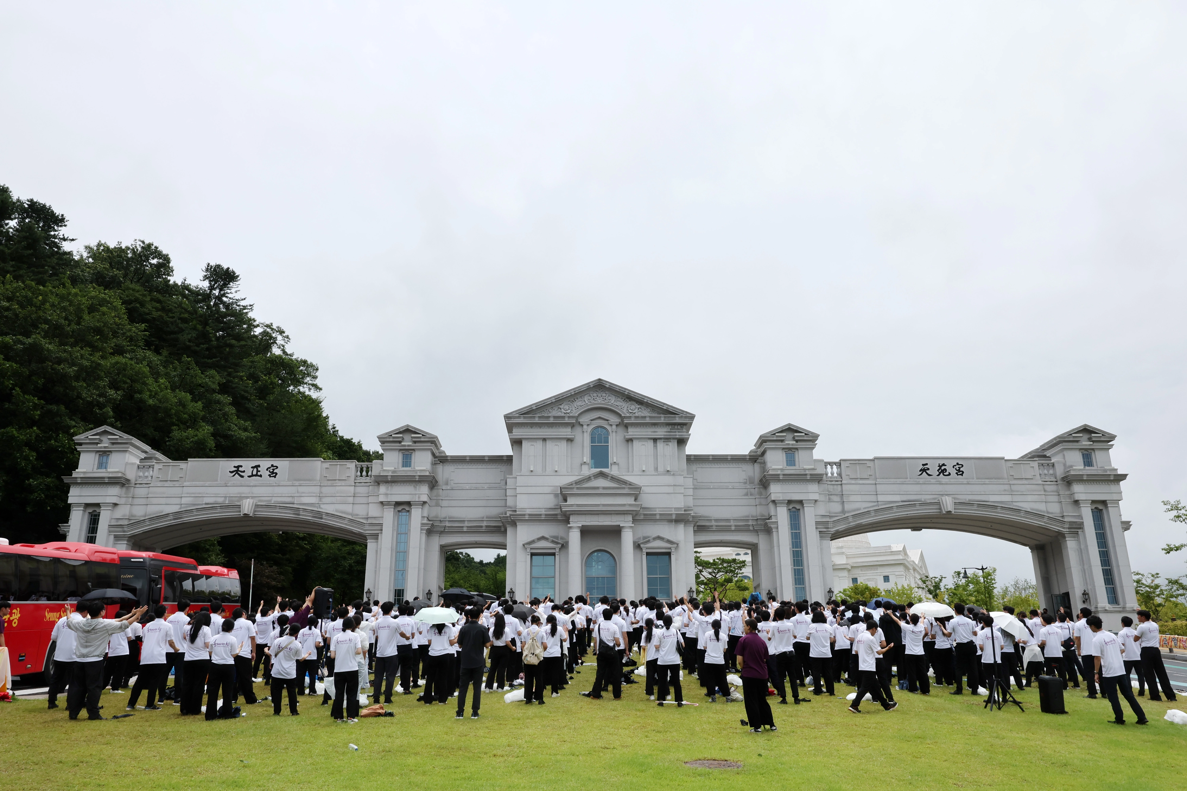 김건희 특검 통일교 압수수색, 천원궁 앞 기도하는 신자들  김건희 여사 의혹을 수사하는 민중기 특별검사팀이 통일교 압수수색에 들어간 18일 오후 경기 가평군 천원궁 앞에서 통일교 외국인 신자들이 기도를 하고 있다. 2025.07.18. 뉴시스