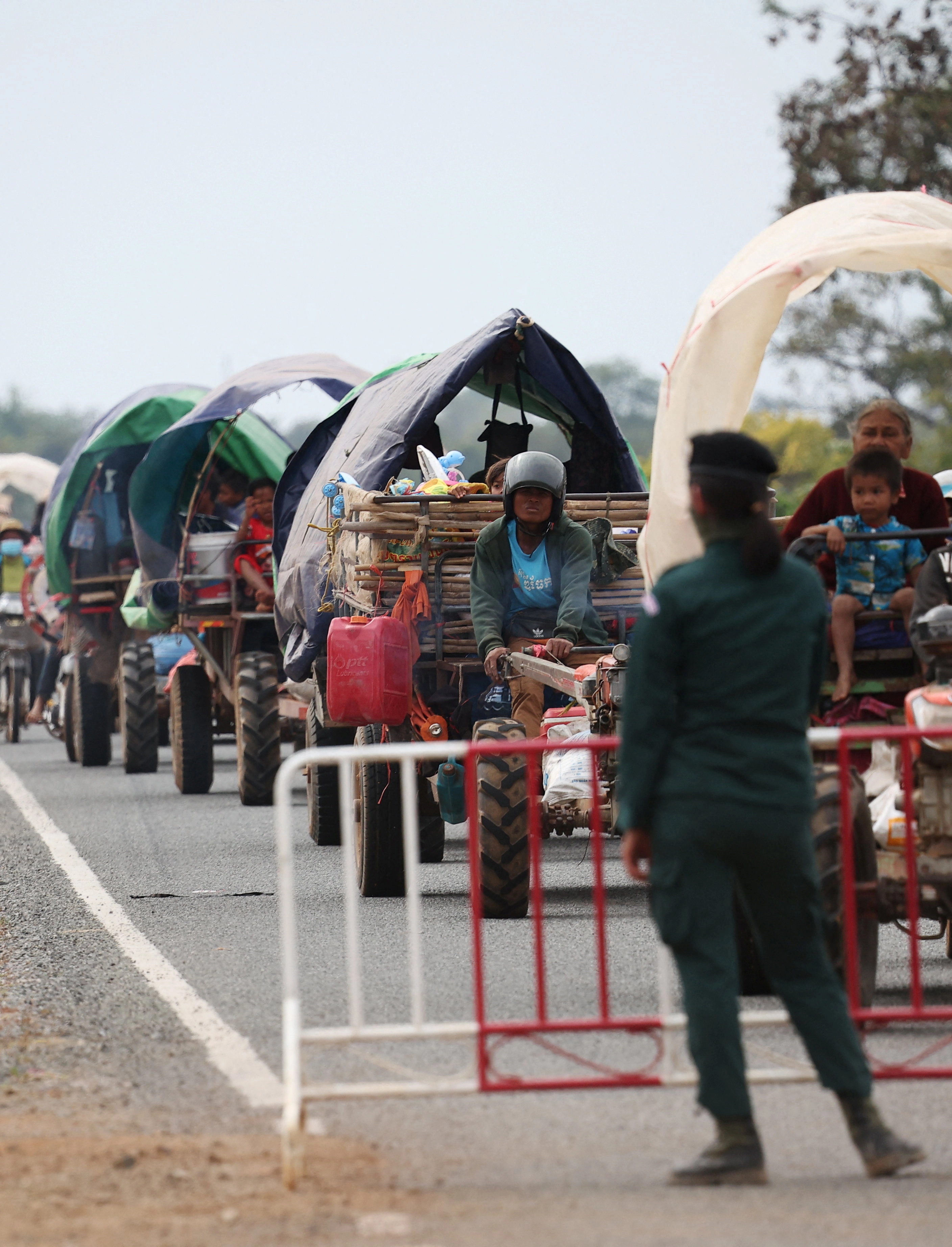 태국과 캄보디아 간의 무력 충돌을 피해 대피하는 사람들을 한 경찰관이 난민 캠프로 안내하고 있다. 오다르민체이 로이터 연합뉴스
