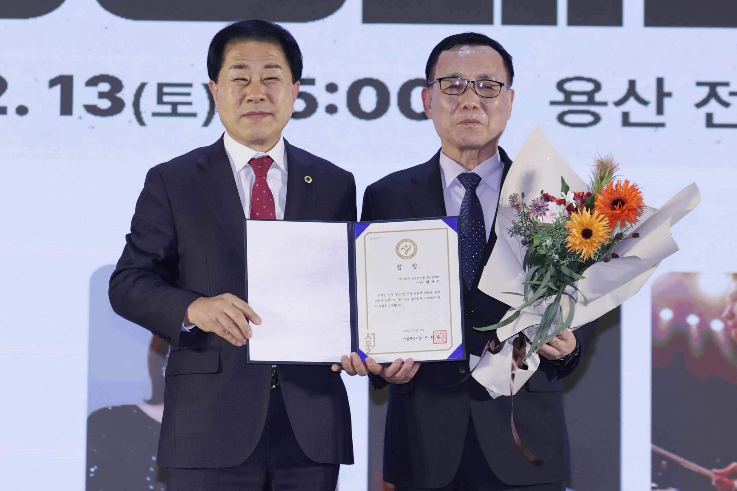 지난 13일 용산 전쟁기념관 이병형홀에서 열린 ‘2025 용산 소상공인ㆍ상점가ㆍ전통시장 상생페스타’에 참석한 김용호 서울시의원(왼쪽)이 반재선 서울시 상점가ㆍ전통시장연합회 이사장에게 지역 상권 발전과 공동체 활성화에 기여 공로로 ‘서울시장상’을 대리 수여하고 수상자와  기념 촬영하고 있다.