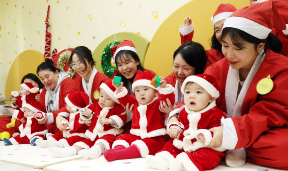 크리스마스를 일주일 앞둔 18일 경기도 광주시 능평도서관에서 한토이어린이서점 주관으로 열린 ‘산타와 함께하는 첫 만남, 책! 행복한 우리 아기를 위한 시간’ 프로그램에서 산타 복장을 한 아기들이 체험형 놀이 활동을 하고 있다. 2025.12.18  공동취재