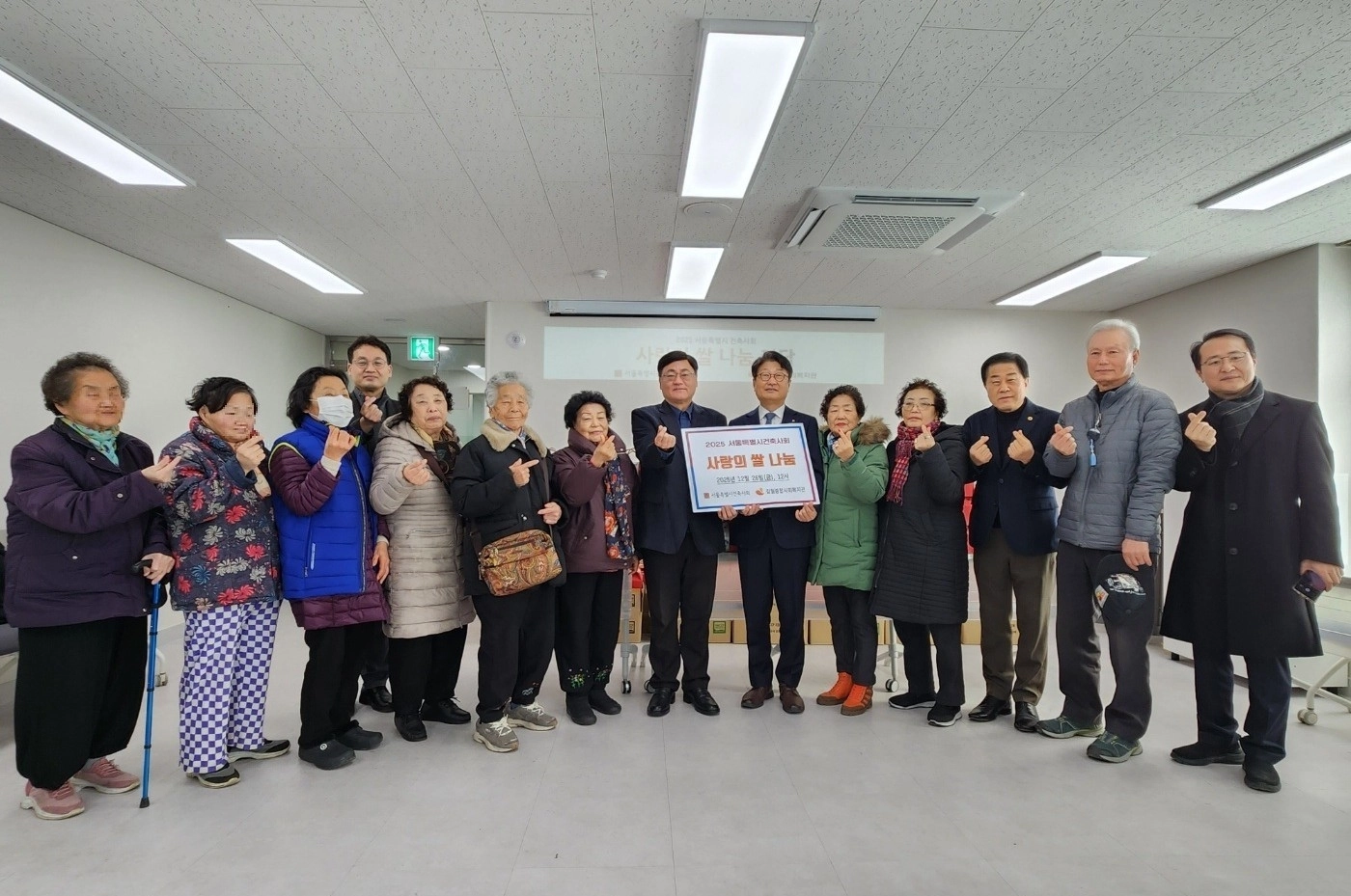 지난 26일 갈월사회복지관에서 열린 ‘어르신들께 사랑의 쌀 나눔 행사’에 참석한 김용호 서울시의원(오른쪽 세 번째)이 쌀 나눔행사의 수여자인 박성준 서울시건축사회 회장 및 임직원과 갈월사회복지관 어르신들과 함께 기념촬영을 하고 있다.